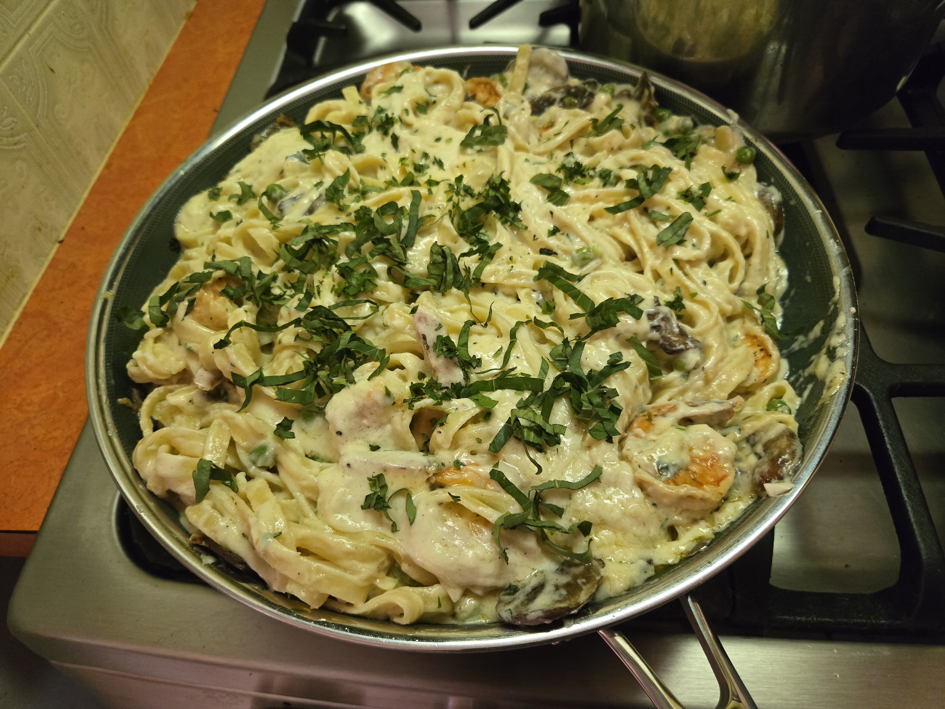 Fettuccine alfredo with shrimp, peas, and cremini mushrooms.